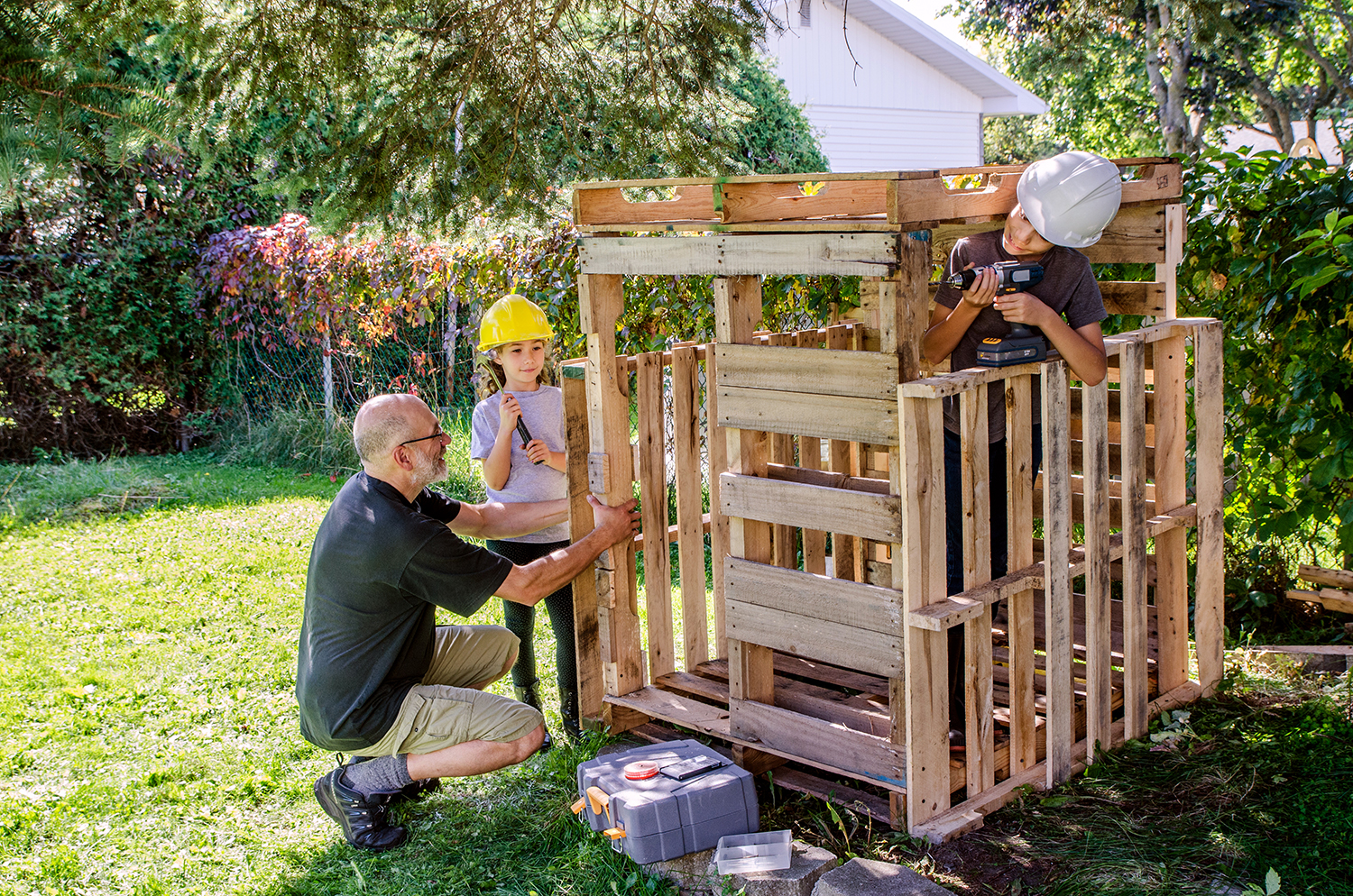 Famille en train de construire une cabane en palette