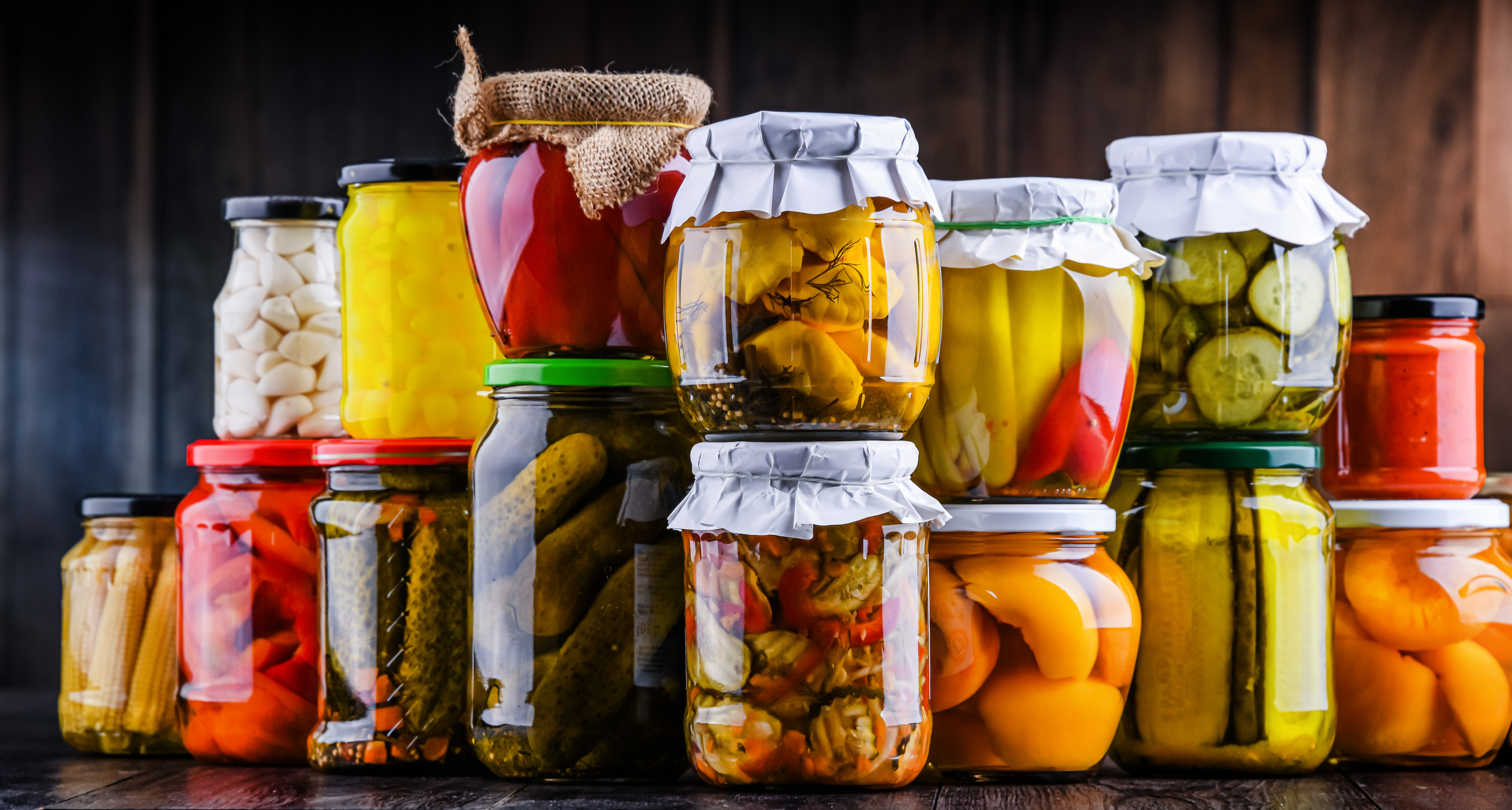 divers bocaux en verre pour la conservation de légumes, fruits, sauces etc. empilés l'un un sur les autres. Conserves faites maison.