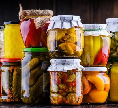 divers bocaux en verre pour la conservation de légumes, fruits, sauces etc. empilés l'un un sur les autres. Conserves faites maison.