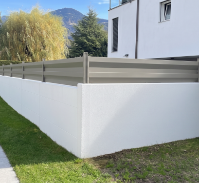 Clôture équipée de lames ModulaiRe en réhausse de mur, finition acier plastifié