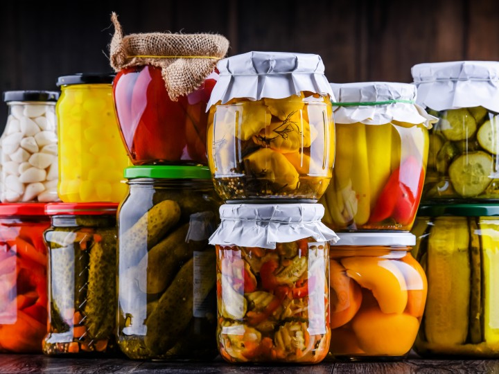 divers bocaux en verre pour la conservation de légumes, fruits, sauces etc. empilés l'un un sur les autres. Conserves faites maison.