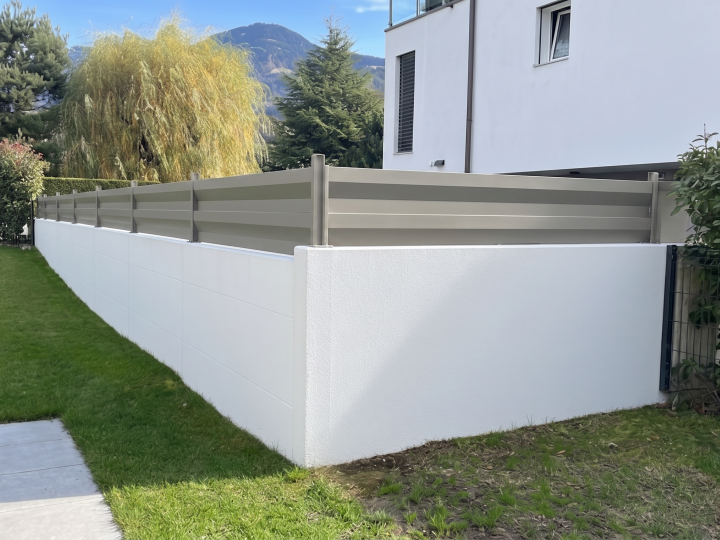 Clôture équipée de lames ModulaiRe en réhausse de mur, finition acier plastifié