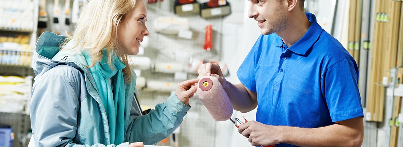 Cliente avec un vendeur dans un rayon peinture d'un magasin de bricolage